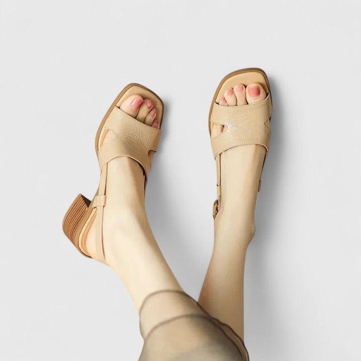 A woman in beige block heel sandals with an ankle strap, dressed for a summer lunch.