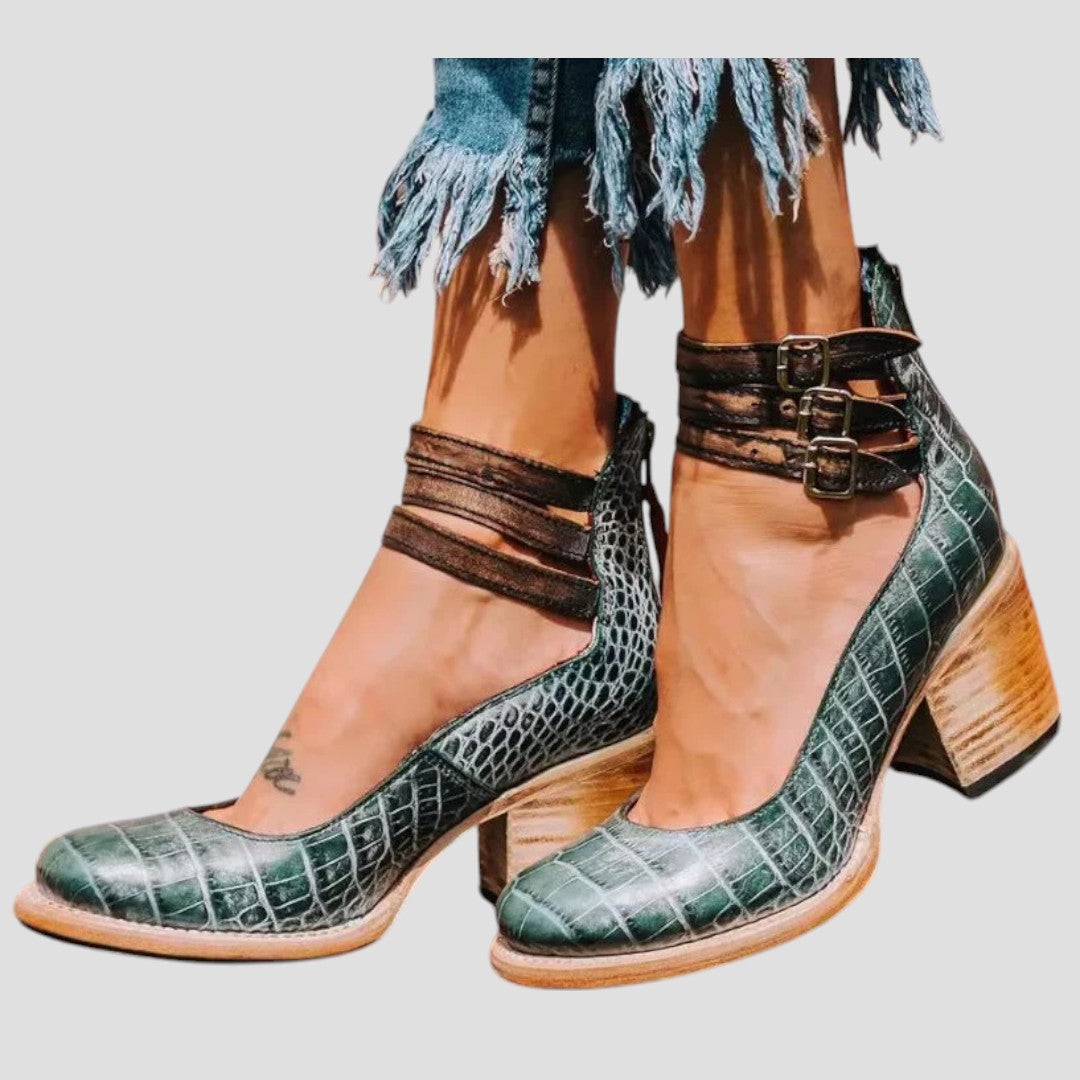 A woman wearing cognac block-heel pumps with triple ankle straps and a rounded toe.