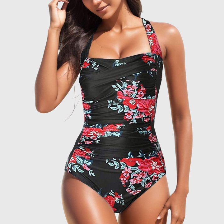 A woman poolside in a patterned one-piece swimsuit, relaxed and confident in the sunshine.
