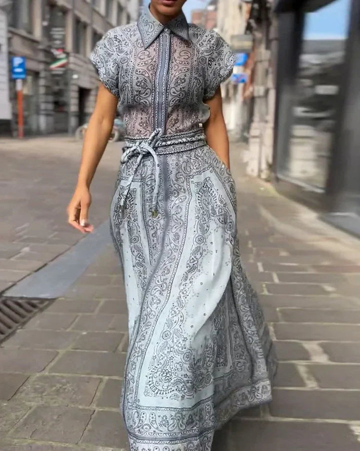 A woman wearing a boho-print top with a flowing midi skirt