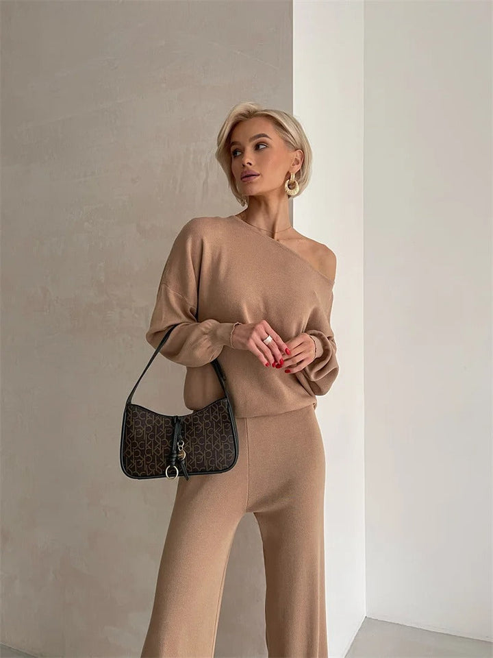 A woman wearing an off-shoulder draped top with wide-leg pants