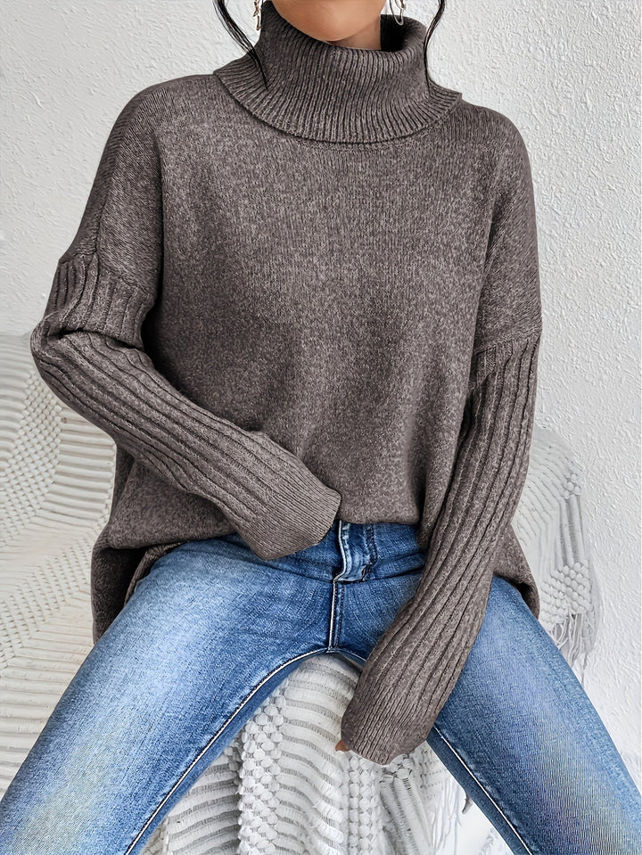 A woman wearing a stand-collar sweater with a chic asymmetric drape, warm and polished.
