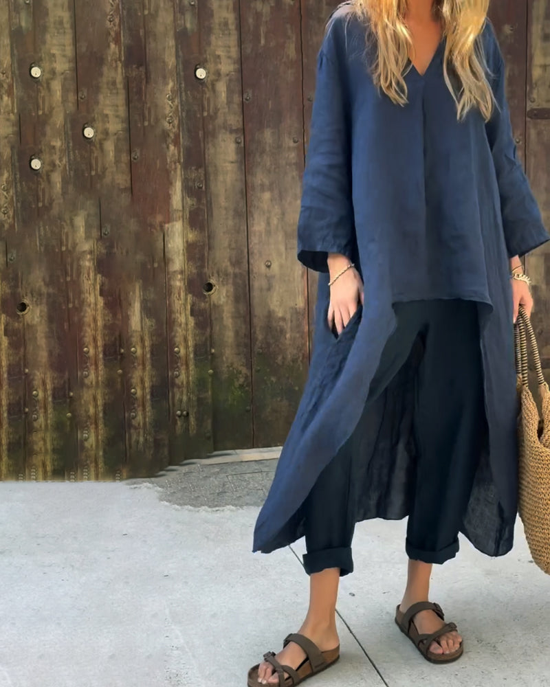 A woman wearing a blue asymmetric tunic with wide-leg pants