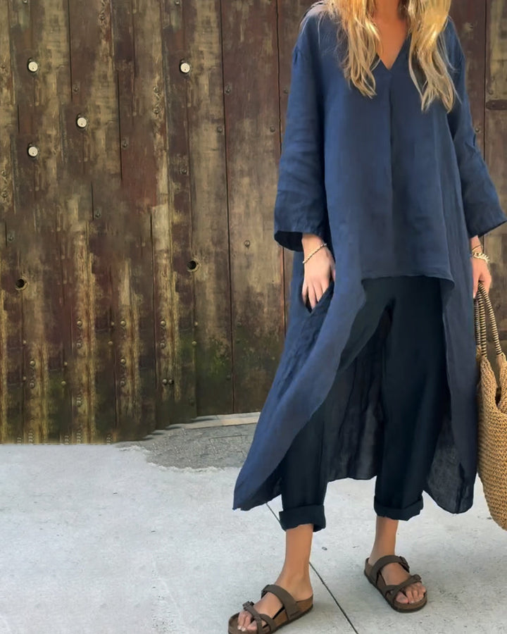 A woman wearing a blue asymmetric tunic with wide-leg pants