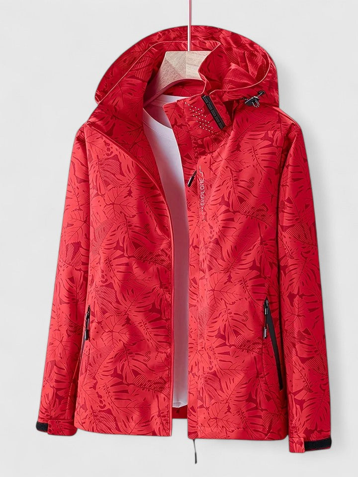 A woman wearing a botanical leaf-print jacket with a hood outdoors