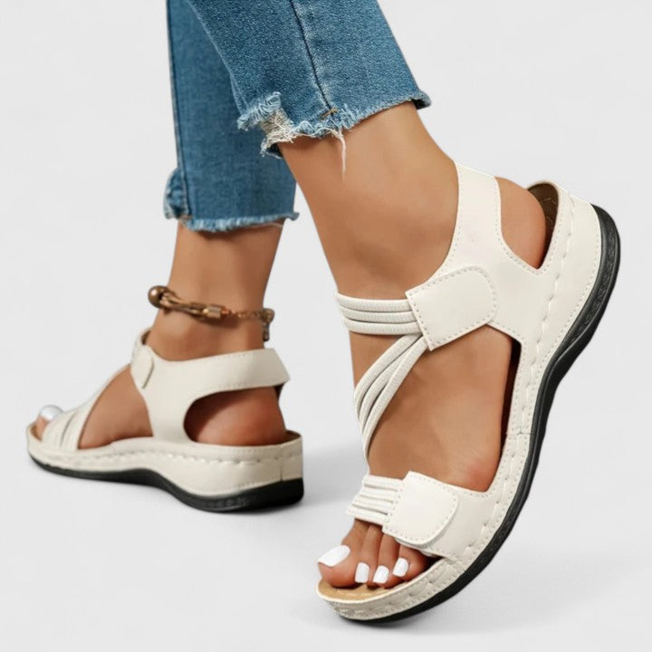 A woman wearing soft adjustable comfort sandals with a summer outfit, looking relaxed and content.