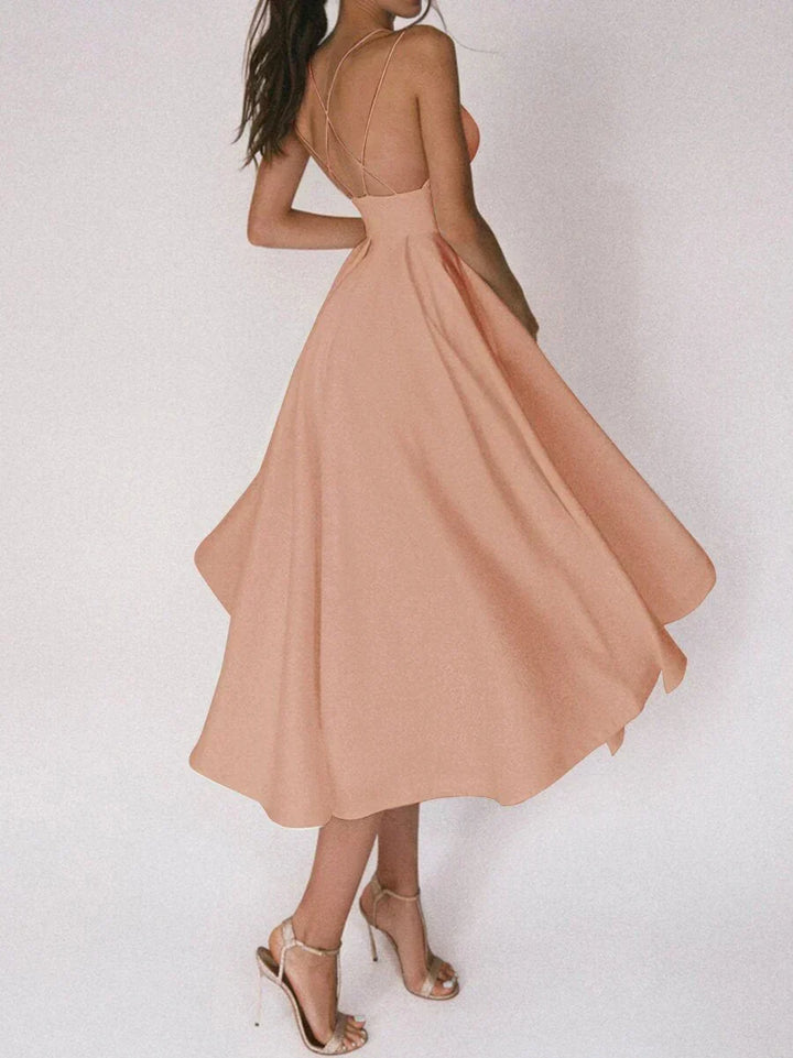 Woman at a summer celebration wearing the Beth minimalist maxi dress with fine double straps and a floating skirt.