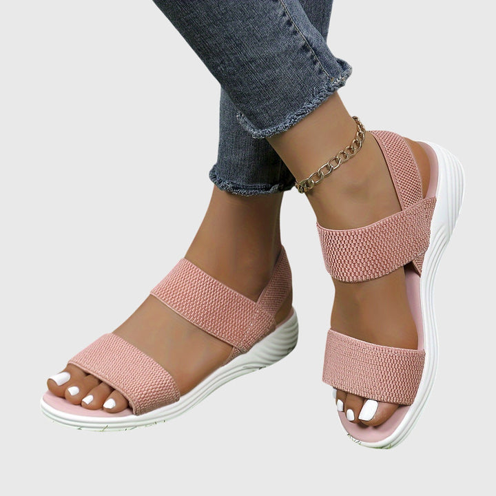 Black open-toe everyday sandals with wide stretch straps and a thick cushioned sole.