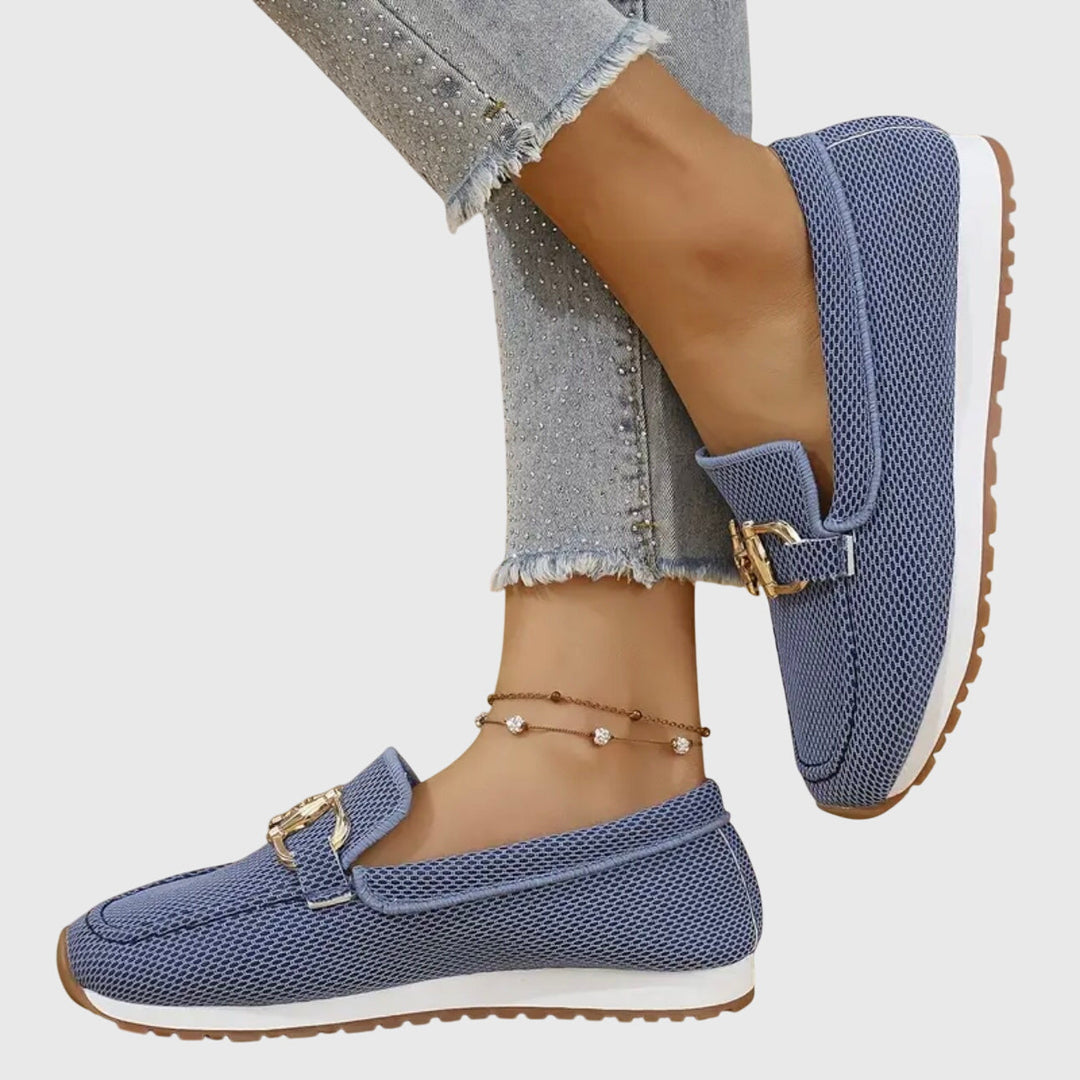 A woman in smart-casual orthopaedic loafer sneakers with a subtle golden detail.