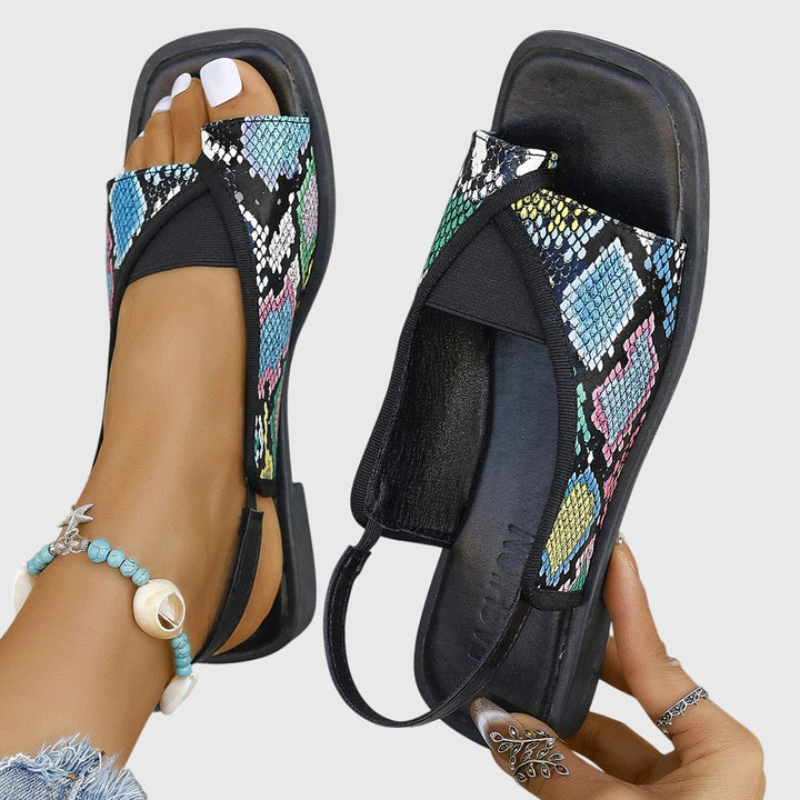 A woman wearing bold two-tone slide sandals on a warm city break.
