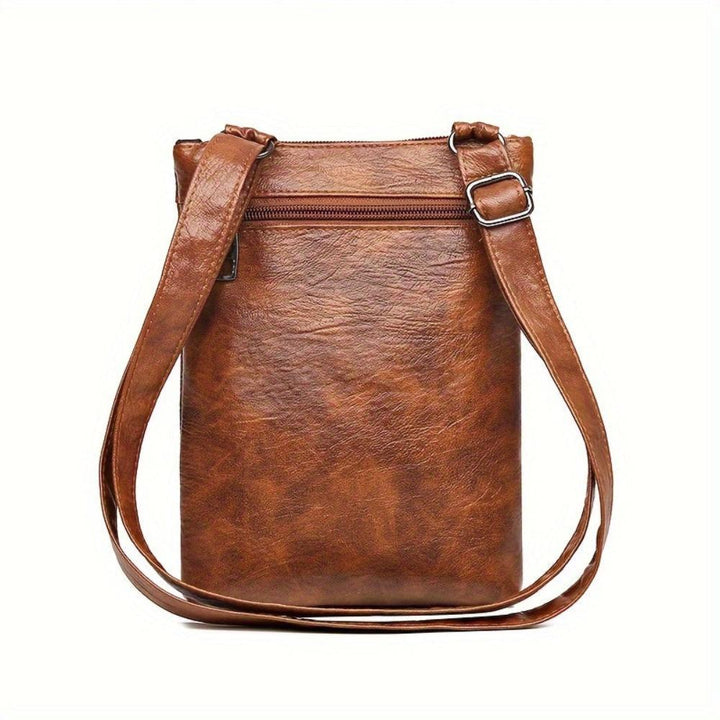 A woman wearing a compact vintage crossbody bag across her body while walking through town.