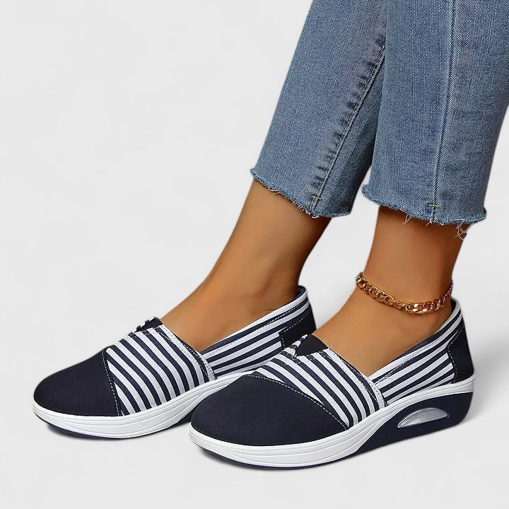 A woman wearing blue striped orthopaedic sneakers on a walk