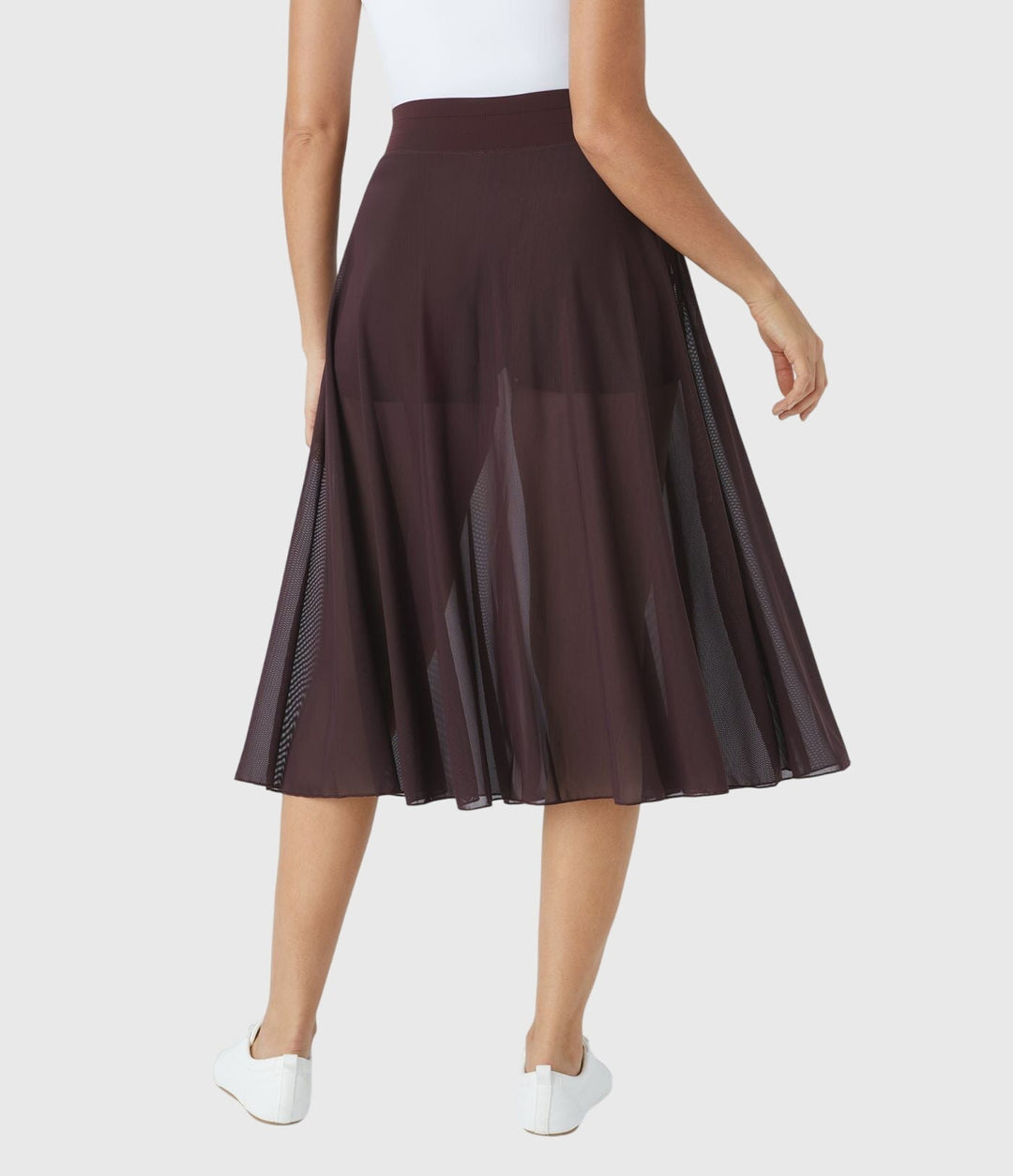 A woman in an elegant high-waisted flowing skirt, styled for a versatile day-to-evening look.