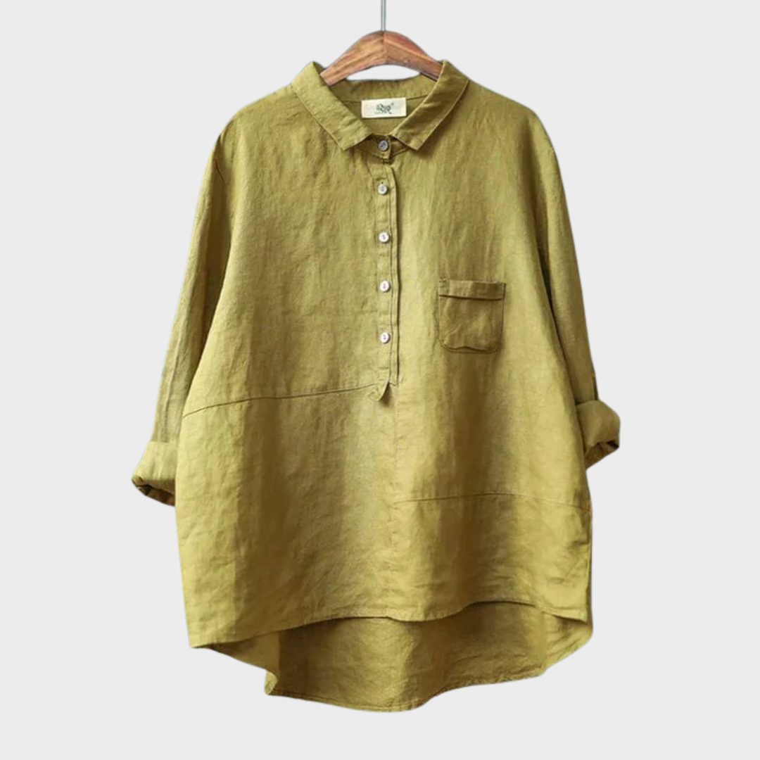 Woman wearing a plain flowing summer blouse in a warm solid colour, falling softly around her figure.