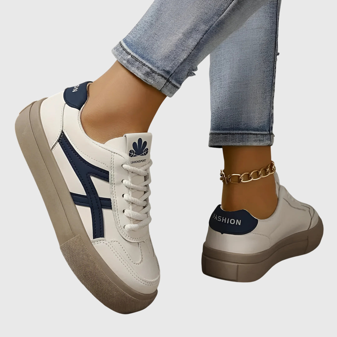 A woman standing comfortably in blue orthopaedic support sneakers with wide stabilising heels.