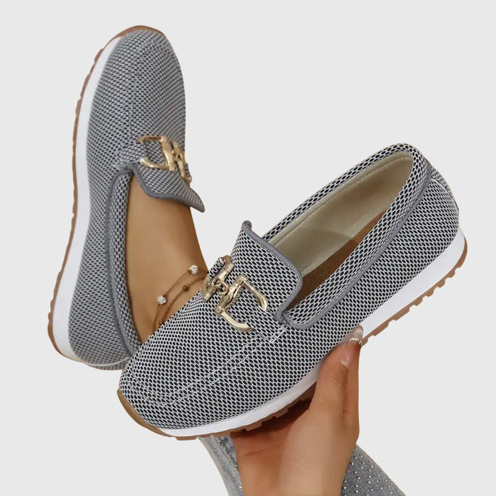A woman in smart-casual orthopaedic loafer sneakers with a subtle golden detail.