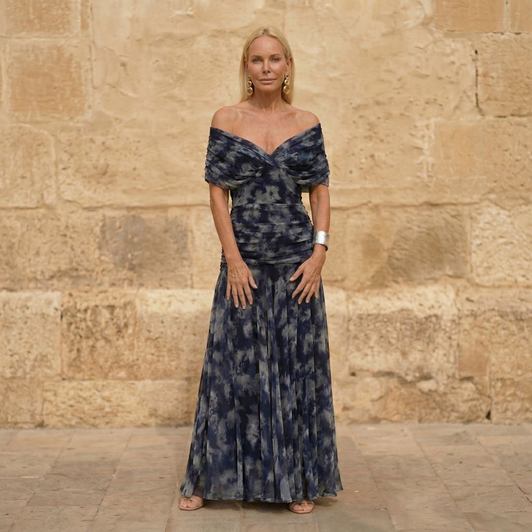 A woman wearing a flowing navy dress with a soft watercolour print at an evening occasion.