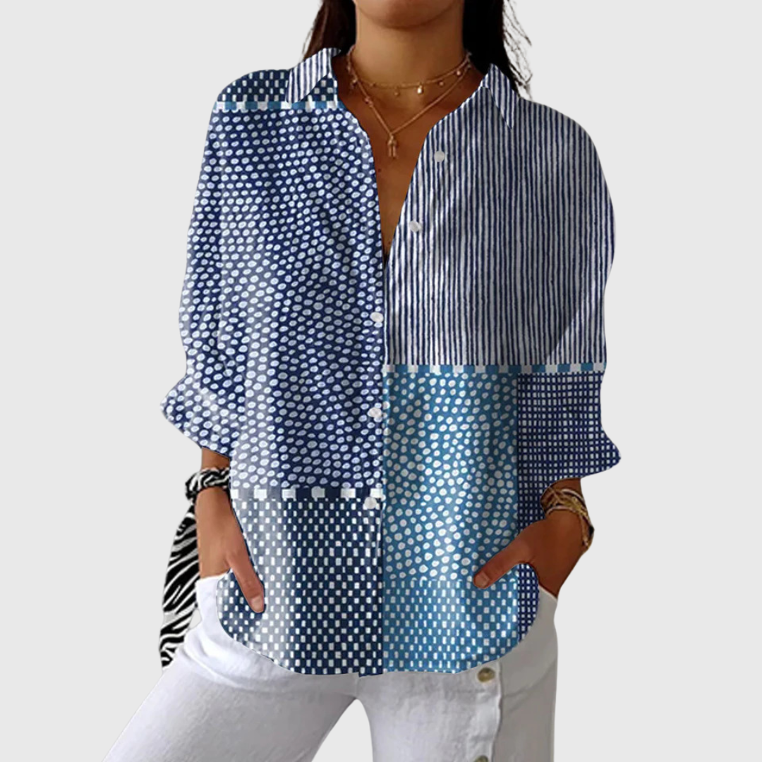 A woman wearing a loose colourful printed blouse with adjustable sleeves, styled with a skirt for a relaxed day out.