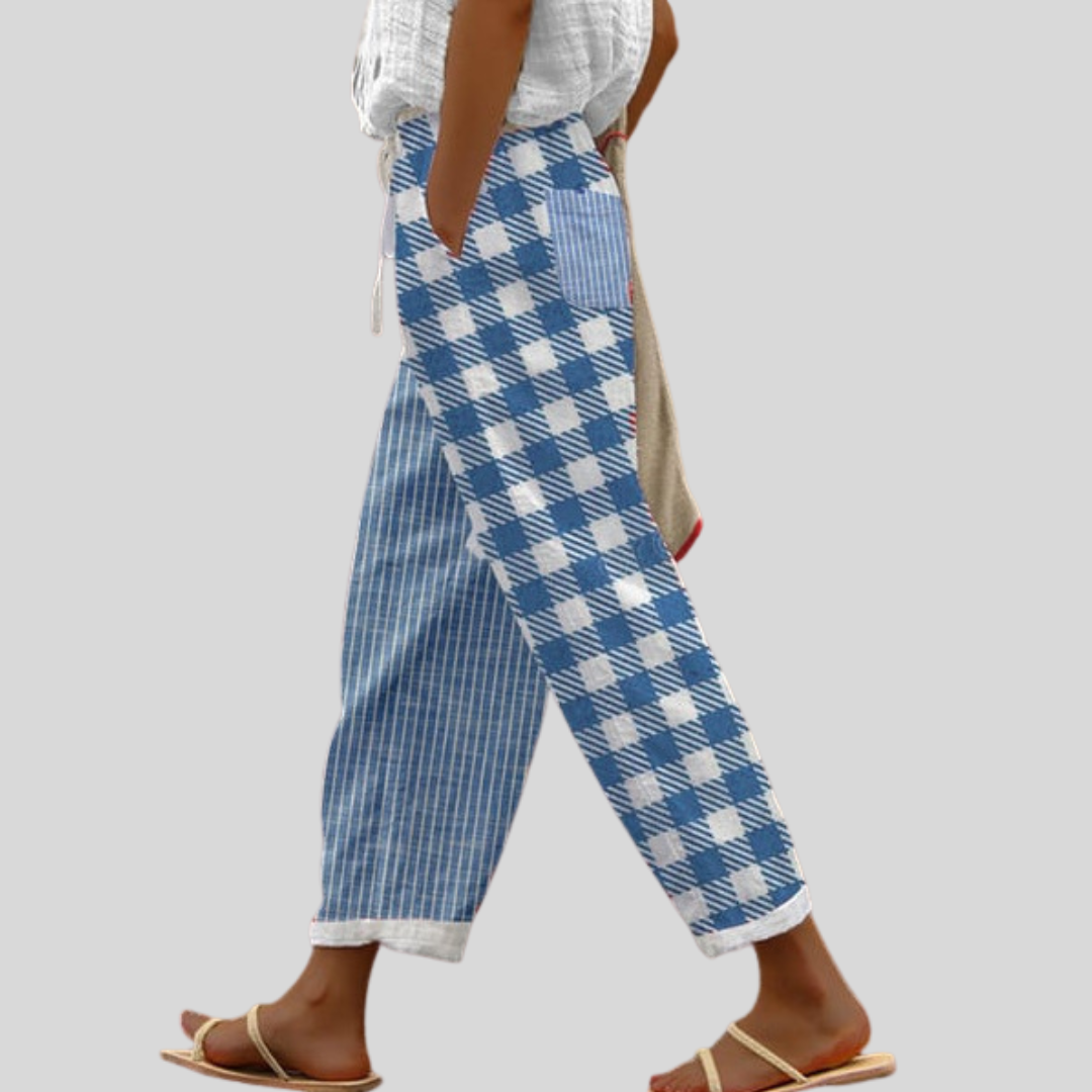 Woman wearing blue and white patchwork pants mixing checks and stripes, with sandals.