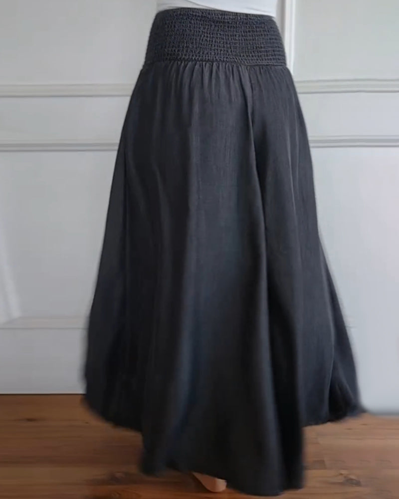Woman wearing high-waist wide-leg pants with a tucked-in blouse, mid-stride.