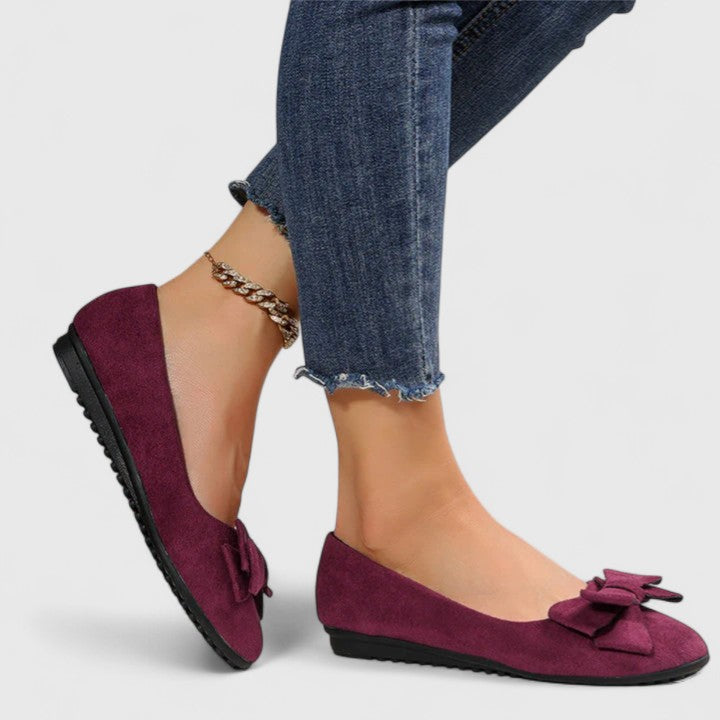 A pair of olive-green ballet flats with a soft bow at the rounded toe.
