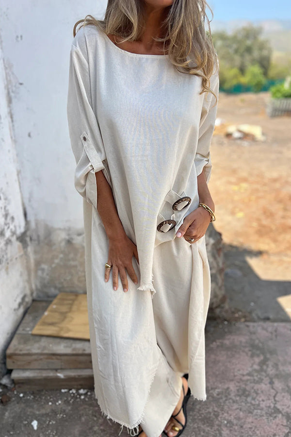 A woman wearing a flowing draped two-piece set with an asymmetric hem, relaxed and elegant.