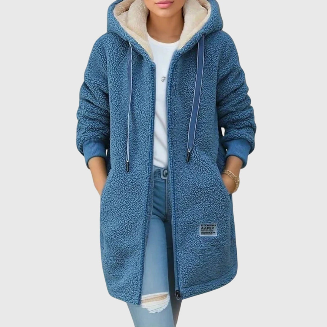 A woman wearing a cosy hooded jacket wrapped up warm on a cold winter morning.