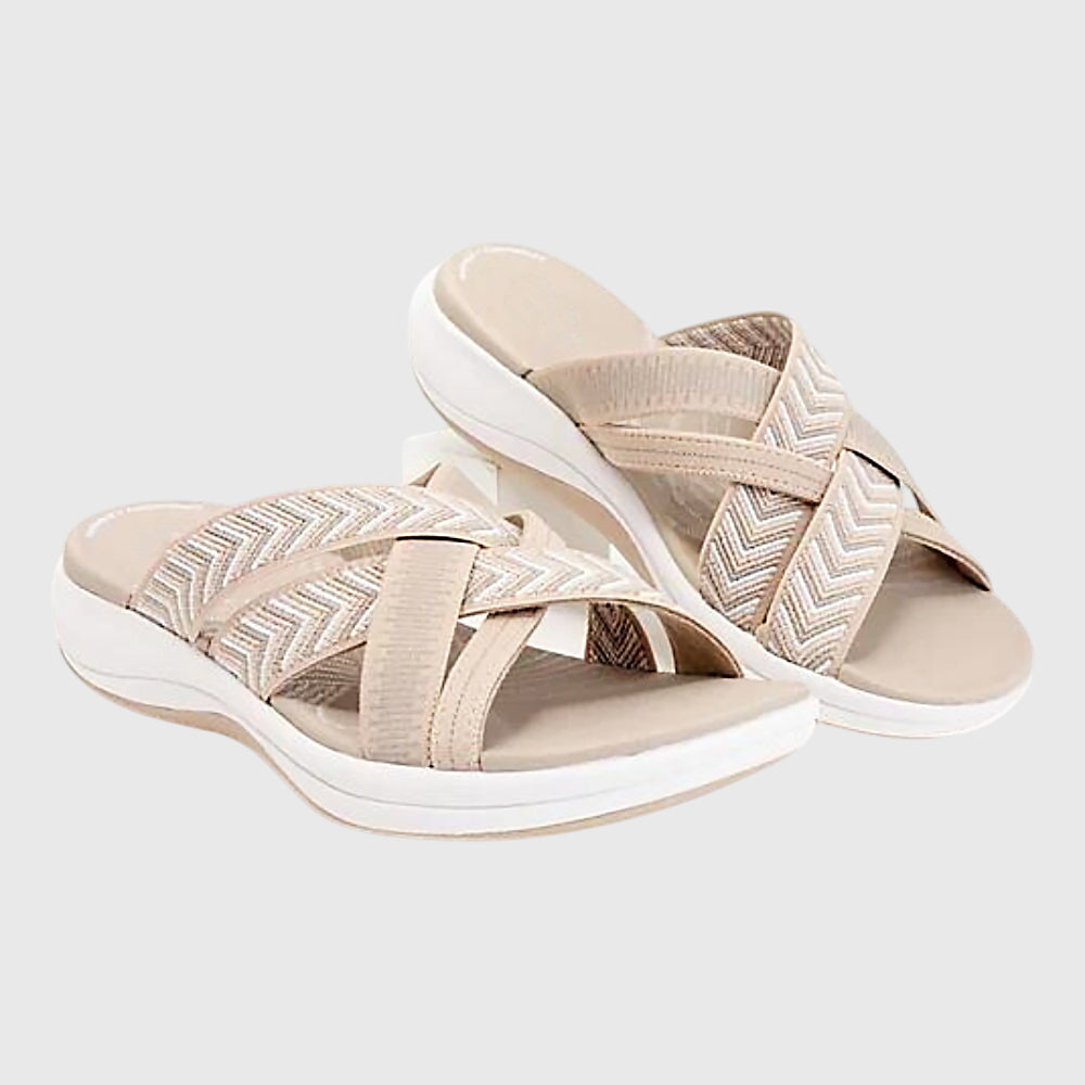 A woman in beige lightweight soft sandals walking easily on a sunny path, feet cushioned and supported.