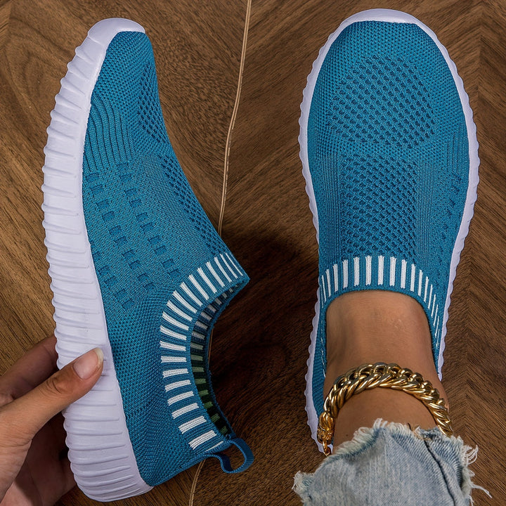 A woman slipping on ultralight sock-style sneakers that hug the foot.