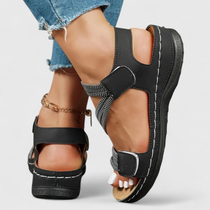 A woman wearing soft adjustable comfort sandals with a summer outfit, looking relaxed and content.