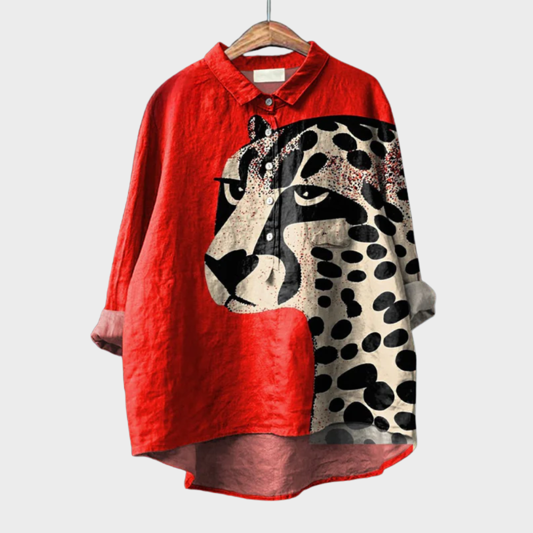 A woman wearing an elegant red summer blouse with a bold leopard motif, looking relaxed and cool on a hot day.