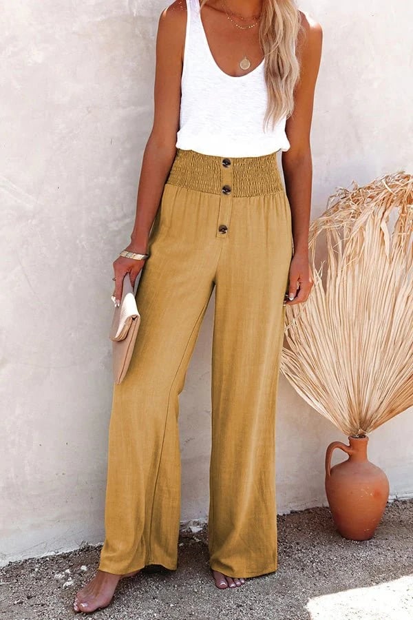 A woman in high-waisted loose wide-leg pants with subtle button detailing, styled for an elegant everyday look.