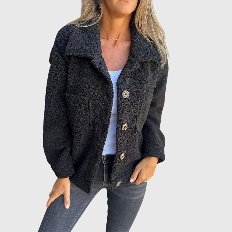 A woman wearing an elegant jacket with a button front over a simple outfit, looking polished.