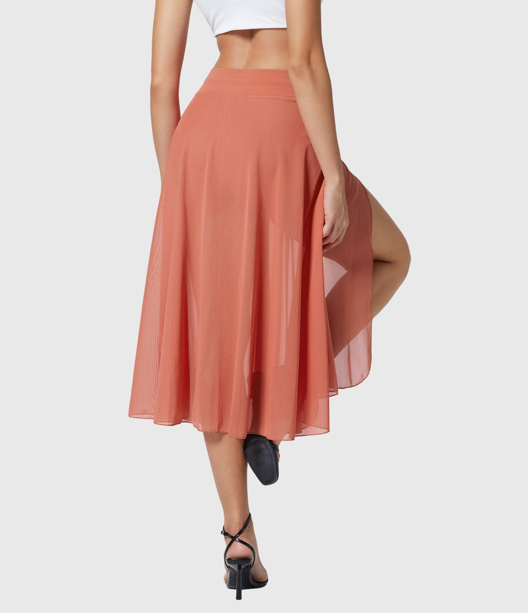 A woman in an elegant high-waisted flowing skirt, styled for a versatile day-to-evening look.