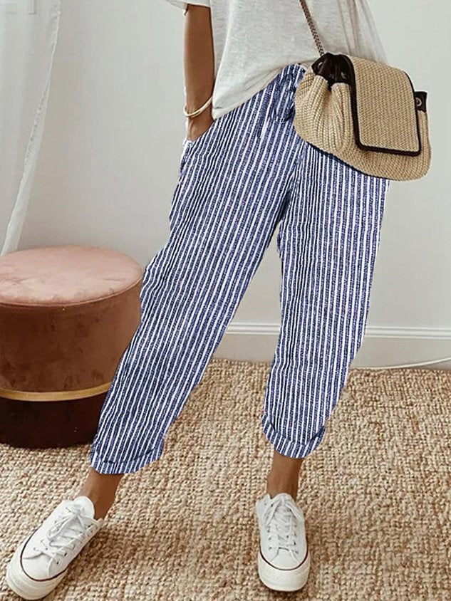 A woman wearing flowing elegant pants with a soft elastic waist and deep pockets.