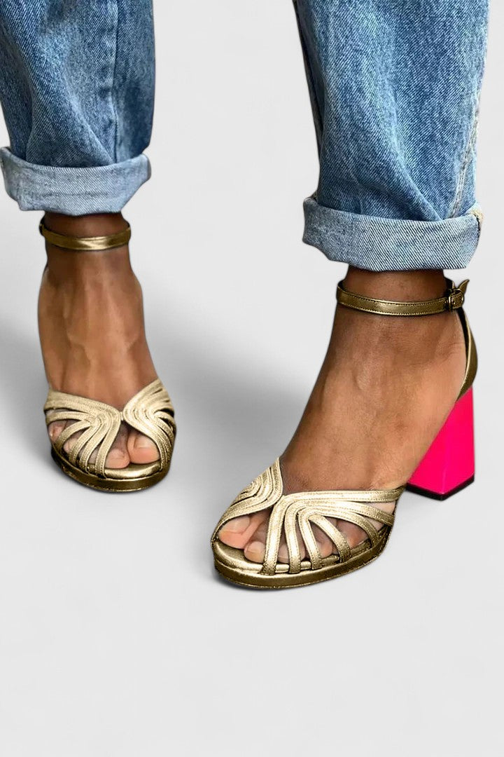 A woman wearing gold open-front heels with an ankle strap, dressed for a special evening.