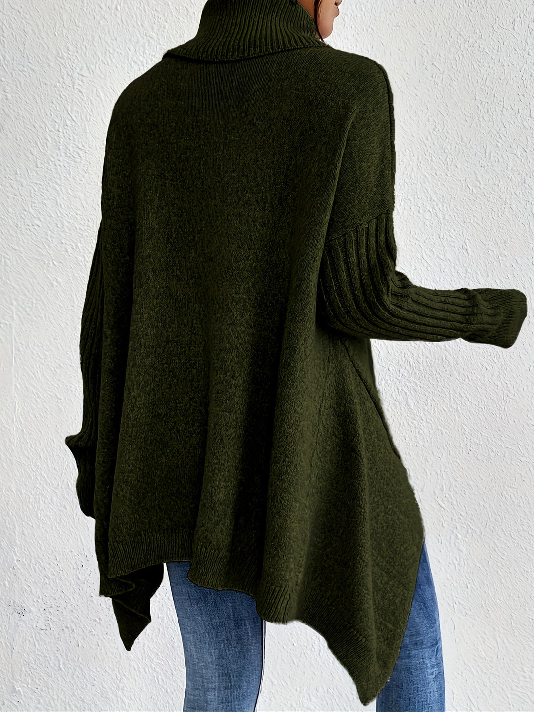 A woman wearing a stand-collar sweater with a chic asymmetric drape, warm and polished.