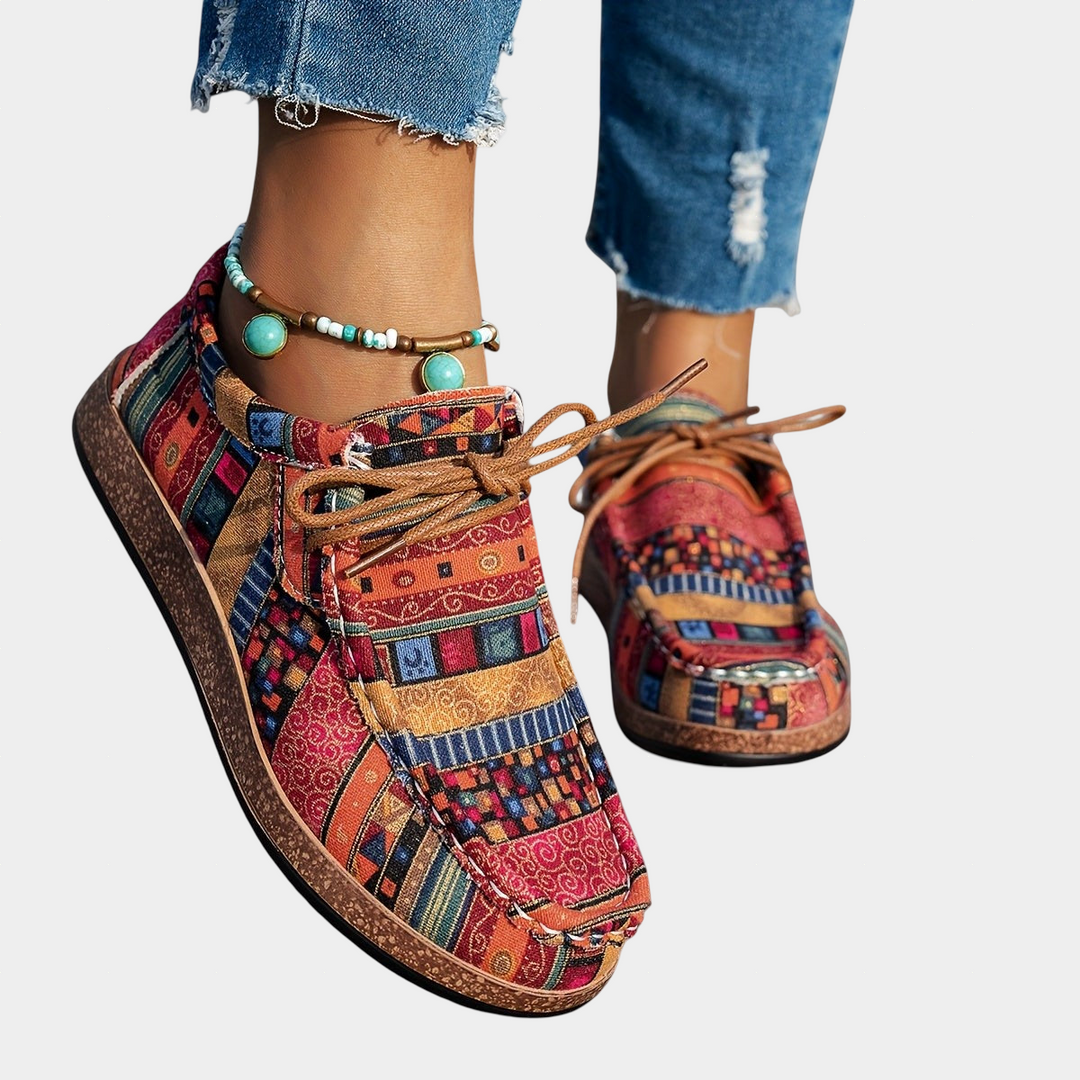 A woman wearing red boho-patterned lightweight sneakers on a walk in town.