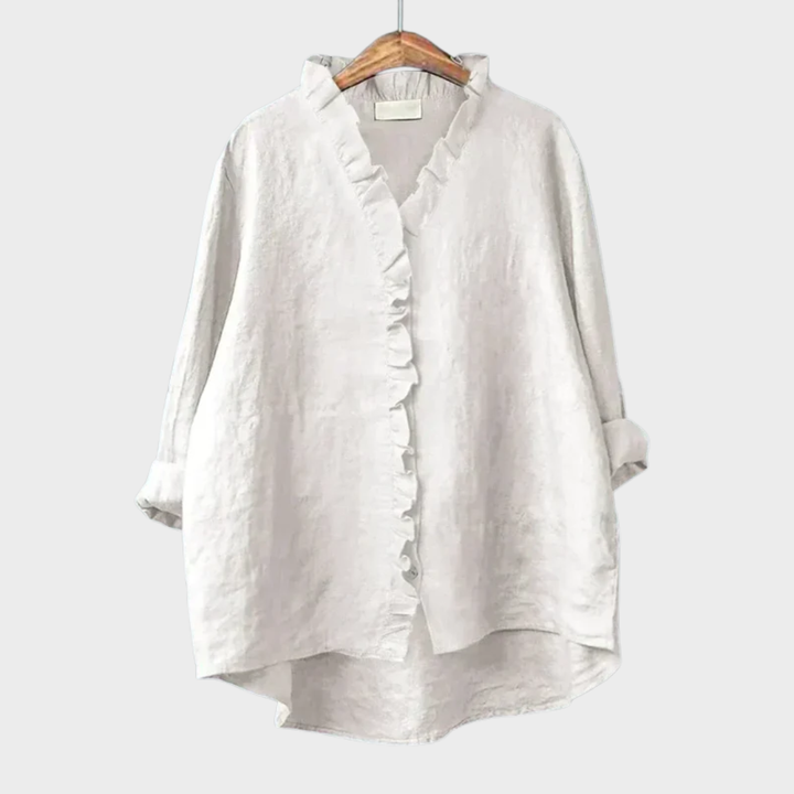Woman wearing a plain ruffle-front summer blouse with a soft, flowing silhouette.