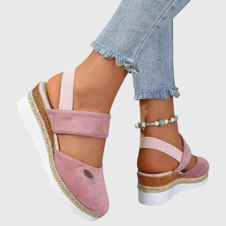 Black closed-toe wedge espadrilles with a wide stretch strap and a braided-trim platform wedge.