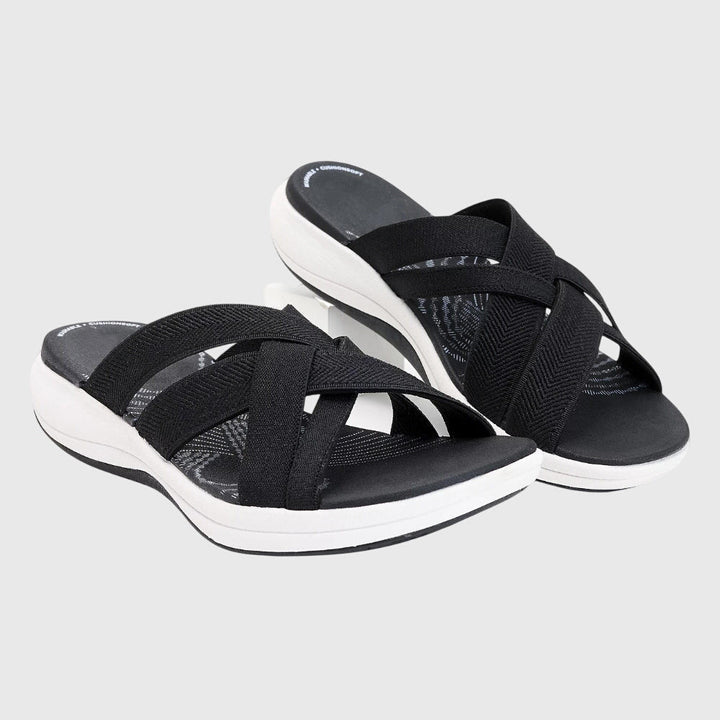A woman in beige lightweight soft sandals walking easily on a sunny path, feet cushioned and supported.