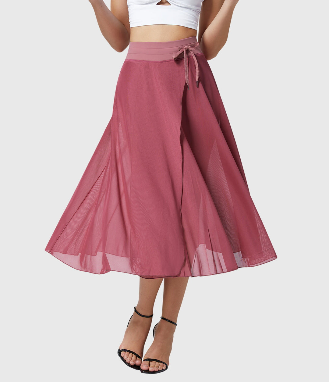 A woman in an elegant high-waisted flowing skirt, styled for a versatile day-to-evening look.