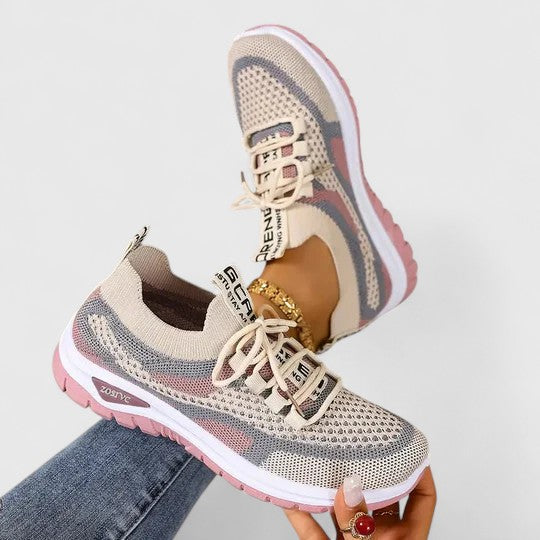 A woman lacing up light, breathable orthopaedic sneakers before a walk.