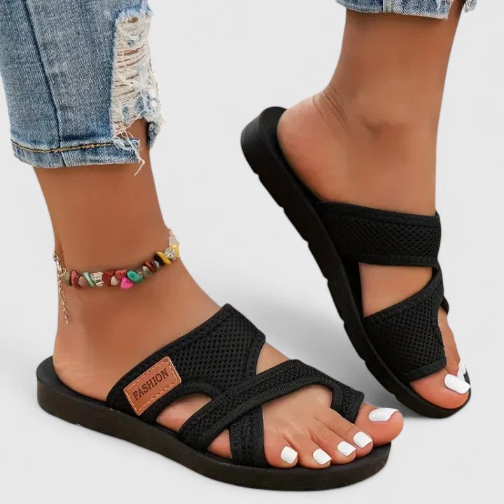 A woman in breathable walking sandals with adjustable straps on a coastal walk.