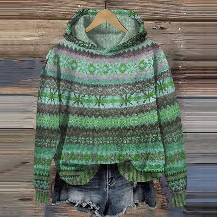 A woman wearing a retro hooded sweater in warm tones with a colourful Nordic pattern.