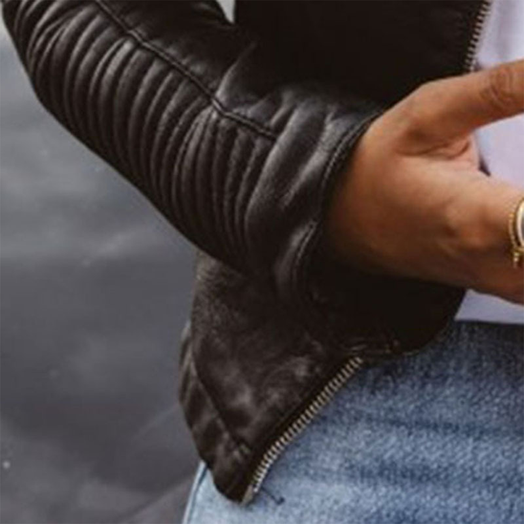 A woman wearing a classic biker jacket with a waisted cut