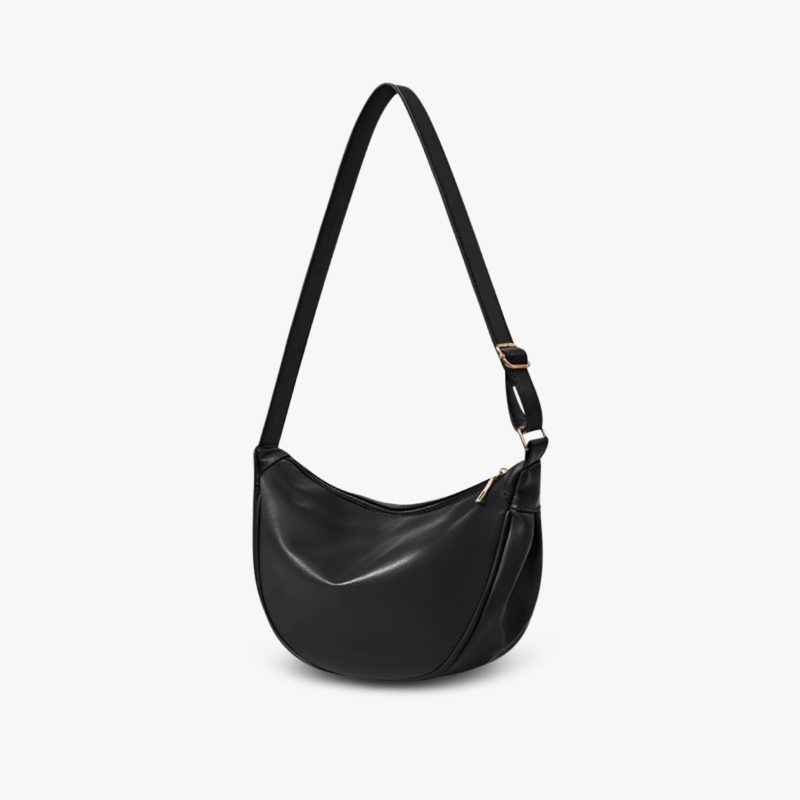 A woman carrying a black crescent-shaped shoulder bag with an adjustable strap