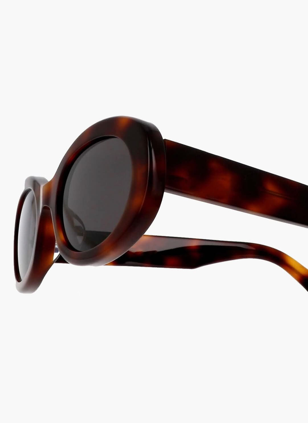 A woman wearing retro oval vintage sunglasses on a sunny day out.
