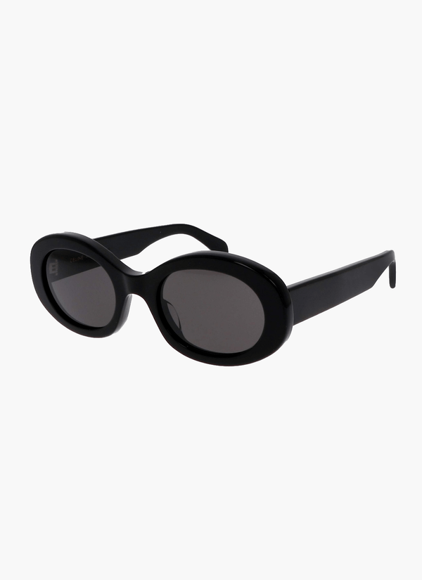 A woman wearing retro oval vintage sunglasses on a sunny day out.