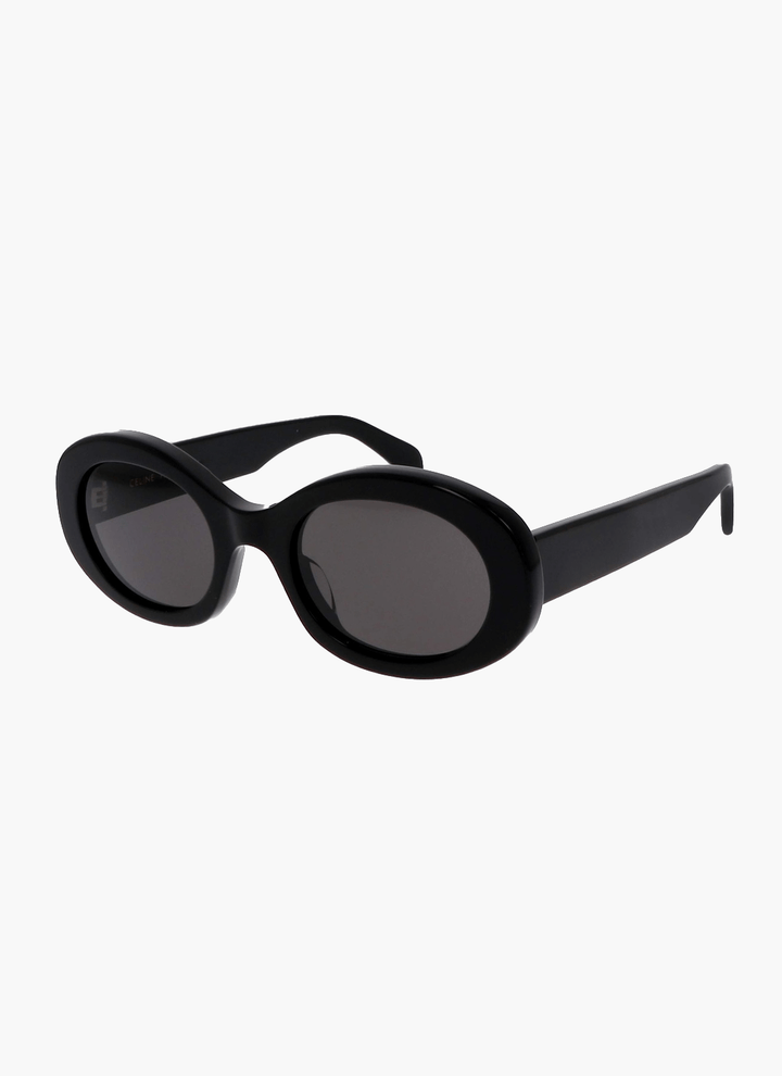A woman wearing retro oval vintage sunglasses on a sunny day out.
